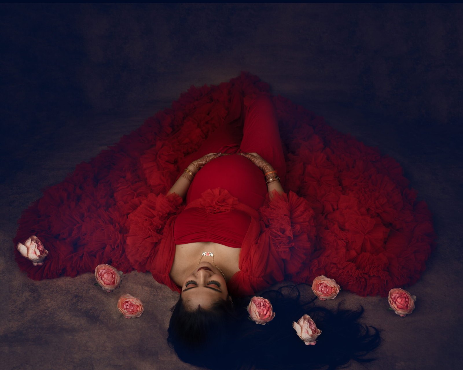 lying down red gown roses maternity